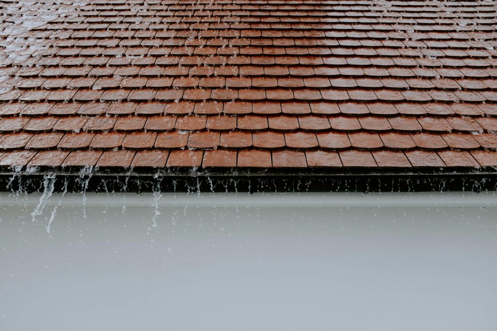 Dirty gutters failing and letting lots of water pour off roof