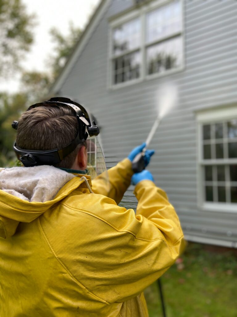 The Cleaners pressure washing the exterior of a house